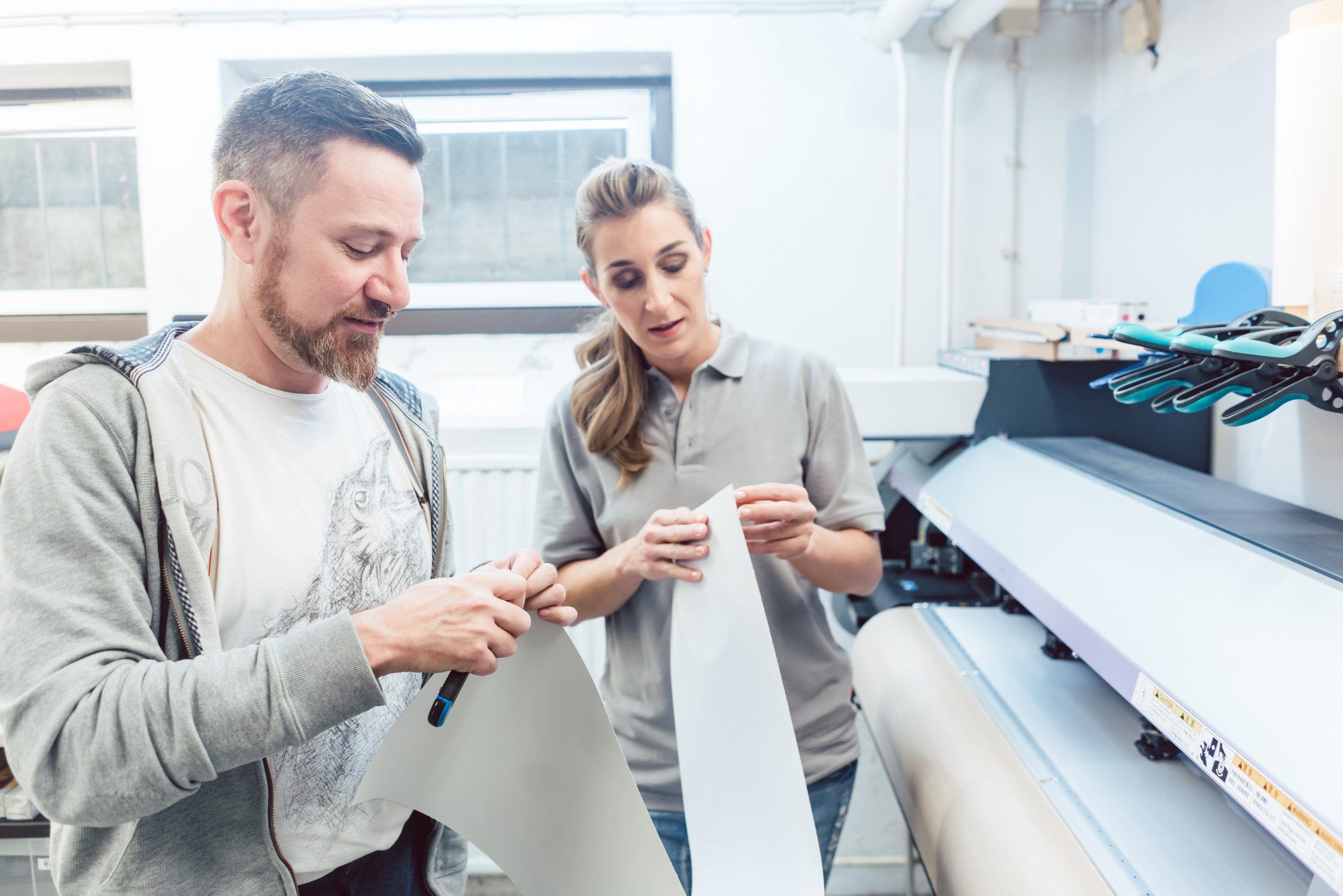 Man and woman discussing a large format print